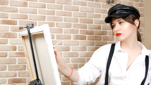 Красивая сексуальная девушка художник рисует картину на пуантах на чердаке — стоковое фото