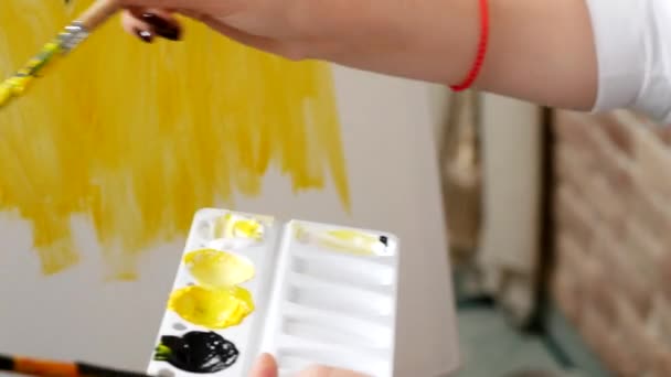 Close-up, o artista faz com que a pintura a óleo na tela. padrão preto e amarelo — Vídeo de Stock