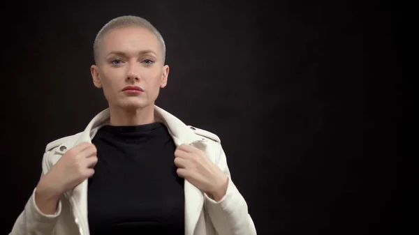 Femme élégante avec les cheveux courts sur un fond noir dans une veste en cuir blanc — Photo