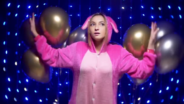 Крупный план. Девушка в розовой пижаме с шариками, смотрящая в камеру. зеленые линзы — стоковое видео
