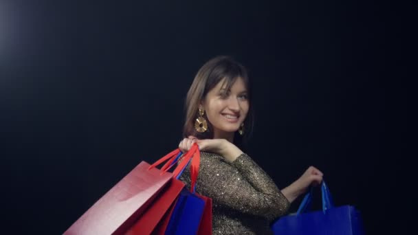 Chica elegante con paquetes sobre fondo negro. descuento de ventas de compras — Vídeo de stock