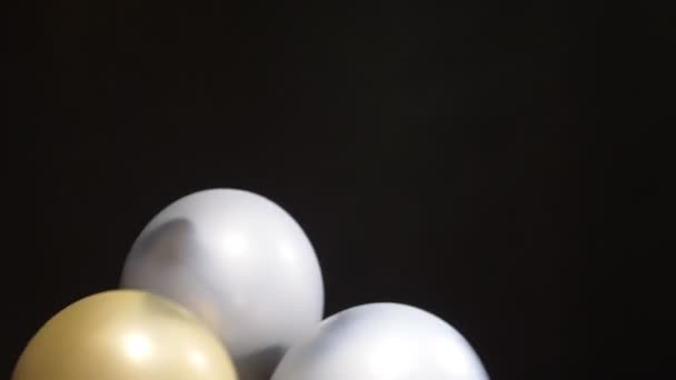 Beaucoup de ballons d'or et d'argent montent en flèche sur fond noir — Video