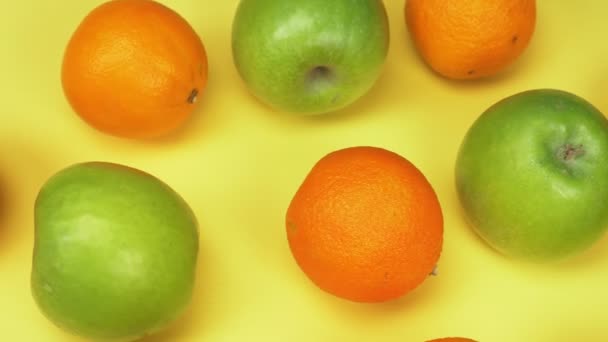Fundo de fruta. laranjas e maçãs verdes no fundo amarelo. design de moda — Vídeo de Stock