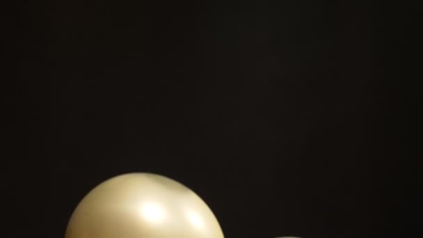 En hel del ballonger av guld och silver svävar på svart bakgrund — Stockvideo