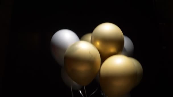 Black package tied to balloons down on black background — Stockvideo
