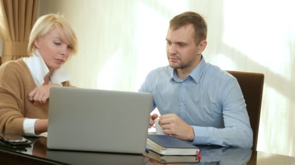 Consultor mulher mostra informações sobre o homem cliente laptop — Vídeo de Stock