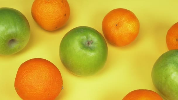 Fondo de fruta. naranjas y manzanas verdes sobre fondo amarillo. diseño de moda — Vídeo de stock