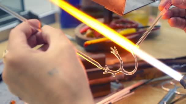 Primer plano de las manos masculinas. hacer artesanías de vidrio por fusión de vidrio en un quemador — Vídeo de stock