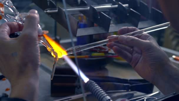 Närbild av manliga händer. göra glashantverk genom att smälta glas på en brännare — Stockvideo