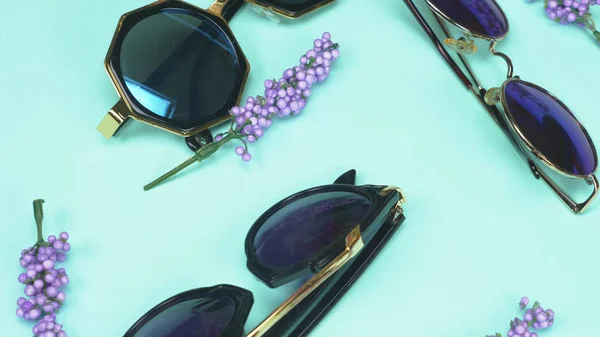 Un ensemble de lunettes de soleil allongées au hasard sur un fond bleu. design de mode — Photo