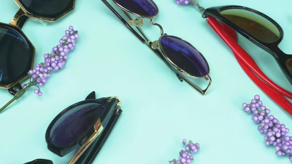 Un ensemble de lunettes de soleil allongées au hasard sur un fond bleu. design de mode — Photo