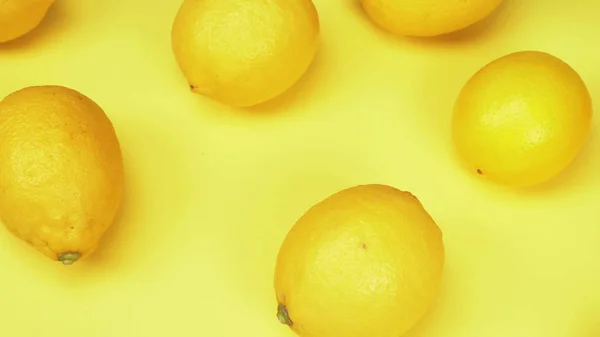 Fondo de fruta. limones maduros sobre un fondo amarillo. diseño de moda —  Fotos de Stock