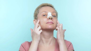 portrait of a happy woman with a bandage on her nose after rhinoplasty