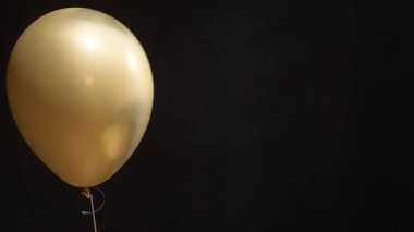 a lone Golden ball up on a black background. copy space