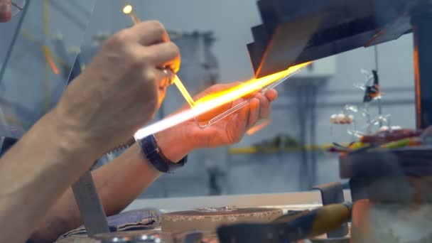 Närbild av manliga händer. göra glashantverk genom att smälta glas på en brännare — Stockvideo