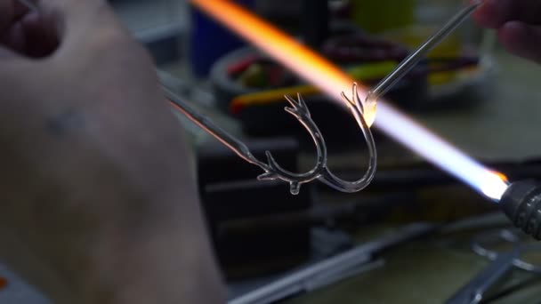 Primer plano de las manos masculinas. hacer artesanías de vidrio por fusión de vidrio en un quemador — Vídeos de Stock