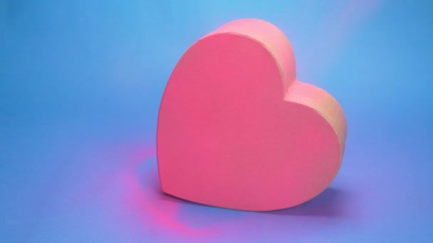Κουτί χρωματισμού σε σχήμα καρδιάς, ροζ σπρέι. μπλε φόντο — Αρχείο Βίντεο