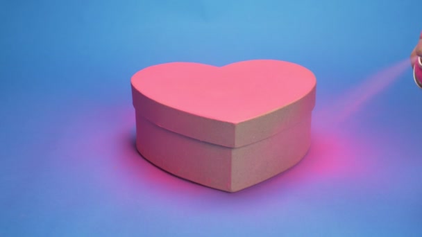 Caja para colorear en forma de corazón, pintura en aerosol rosa. fondo azul — Vídeo de stock