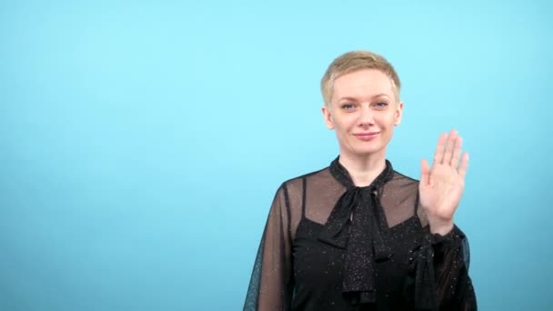 ループビデオアートデザインならねスタイリッシュなエレガントな女性が手を振っている。青の背景 — ストック動画