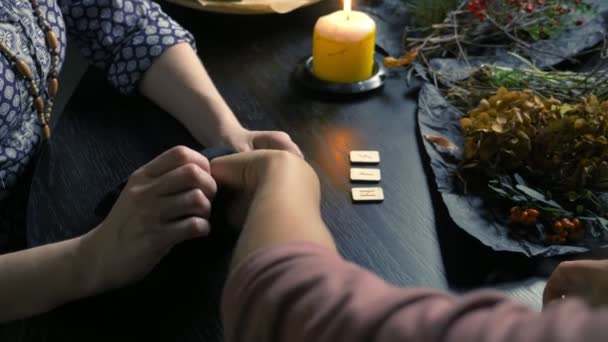 Vrouwelijke witte goochelaar voorspelt de toekomst door runen. runic magie — Stockvideo