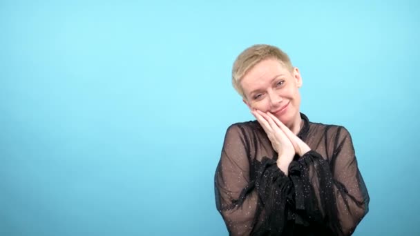 Loop video. GIF design. woman tenderly looking at the camera. blue background — Stock Video