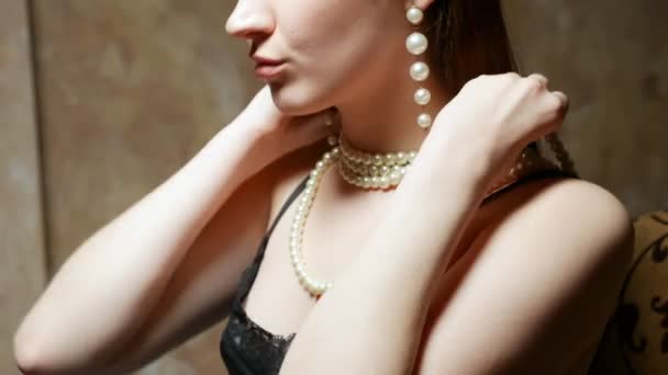 Joven hermosa chica lleva un collar de perlas blancas . — Vídeos de Stock