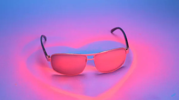 Gafas de sol están pintadas de color rosa con pintura en aerosol sobre un fondo azul —  Fotos de Stock