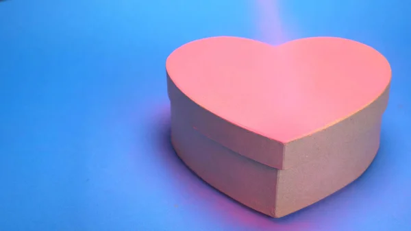 Coloring box in the shape of a heart, pink spray paint. blue background — 스톡 사진