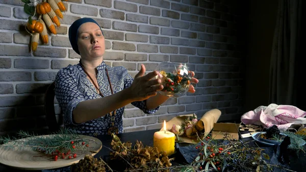 pagan ritual magic. a potion of herbs. the woman is a witch preparing herbal