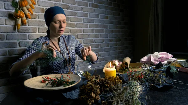 pagan ritual magic. a potion of herbs. the woman is a witch preparing herbal