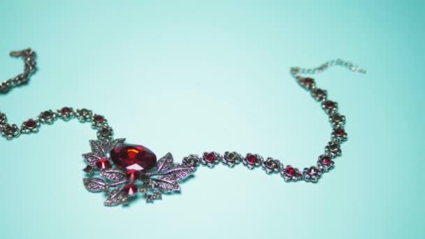 Collar de plata con rubí sobre un fondo azul. diseño de moda — Vídeos de Stock