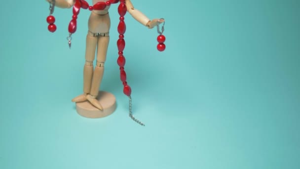 Red coral jewelry hanging on a wooden human mannequin. blue background — Stockvideo