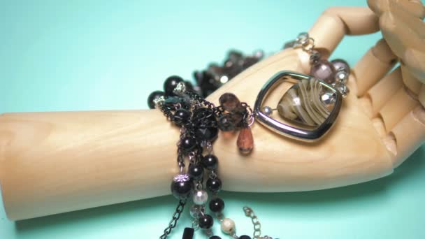 Perles d'agate noires sur un bras en bois. fond bleu — Video