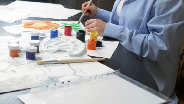 Beautiful young girl draws paints in the Studio . against a brick wall — Stockvideo