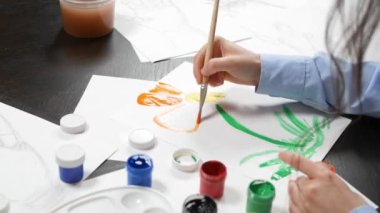 beautiful young girl draws paints in the Studio . against a brick wall