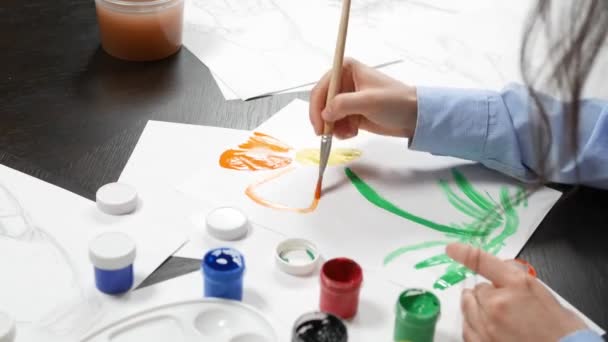 Beautiful young girl draws paints in the Studio . against a brick wall — 图库视频影像