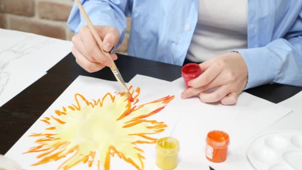 Beautiful young girl draws paints in the Studio . against a brick wall — Stock Video