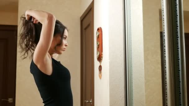 Mädchen macht zu Hause vor dem Spiegel ein paar Haare — Stockvideo