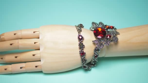 Necklace with ruby hanging on a wooden mock hands. blue background — 图库视频影像