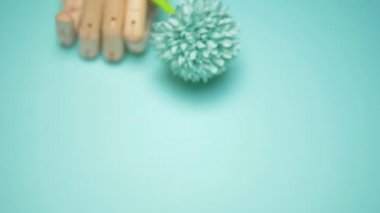 wooden hand holding artificial flowers. blue background