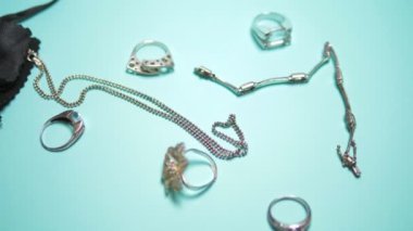 silver jewelry and black pouch on a blue background
