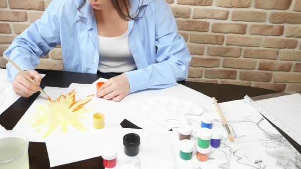 Krásná mladá dívka kreslí barvy ve studiu. proti cihlové zdi — Stock video