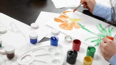 beautiful young girl draws paints in the Studio . against a brick wall