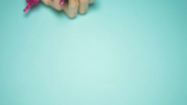 wooden hand holding an artificial butterfly . blue background