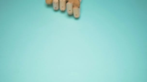 Mano de madera sosteniendo la raíz de jengibre sobre un fondo azul. espacio de copia — Vídeos de Stock