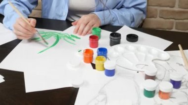 beautiful young girl draws paints in the Studio . against a brick wall