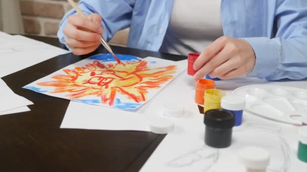 Beautiful young girl draws paints in the Studio . against a brick wall — 图库视频影像