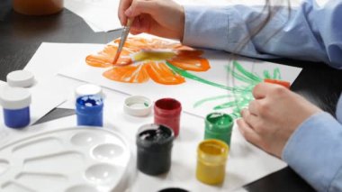 beautiful young girl draws paints in the Studio . against a brick wall