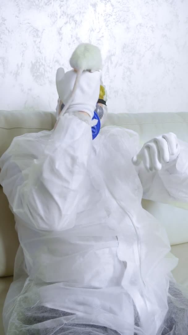 Man in beschermend pak en masker kijkt naar een witte rat — Stockvideo