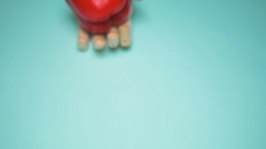 Tahta el kırmızı dolma biberi tutuyor. mavi arkaplan